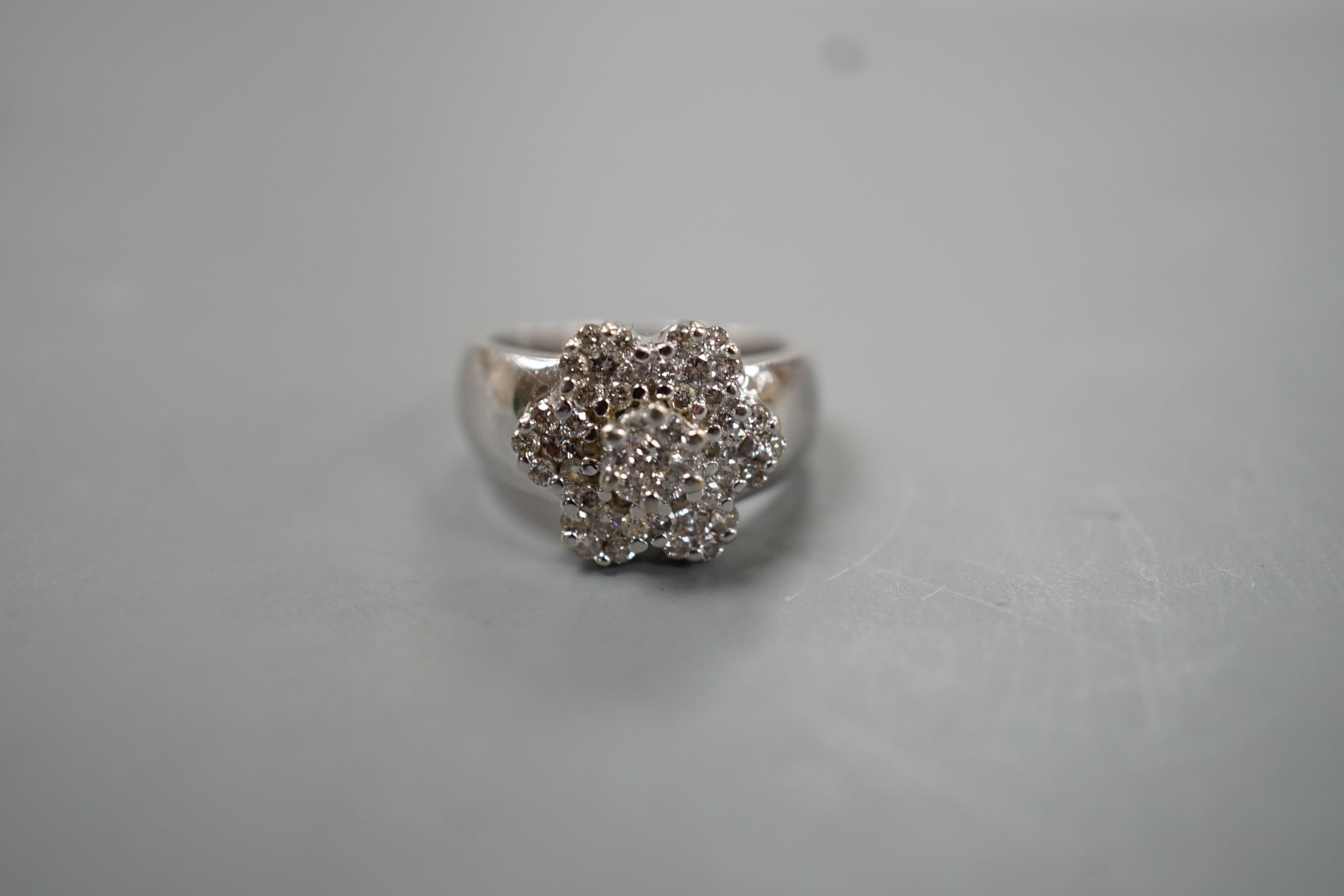A modern 14k white metal and multiple diamond cluster set flower head ring, size M, gross weight 8.7 grams.